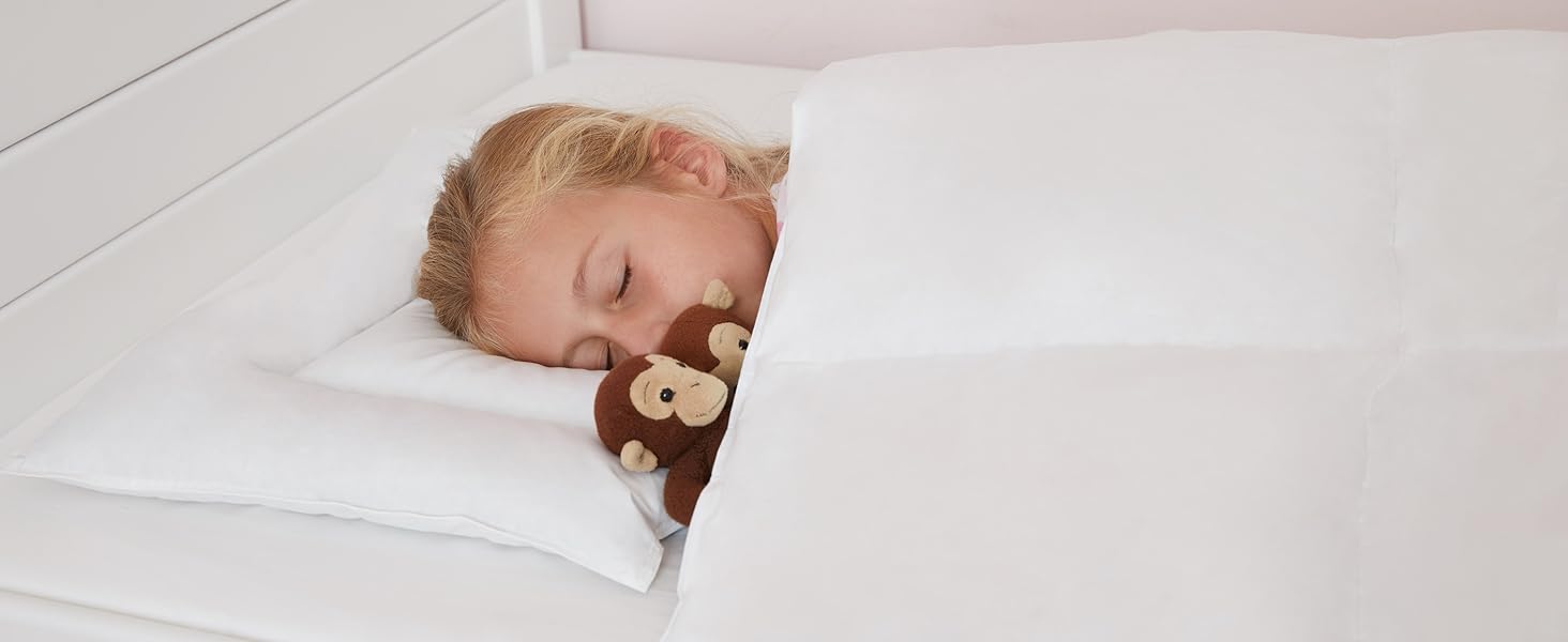 Enfant couché dans une couette et une housse de couette de Koru Kids