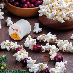 TRIXES Clear Spool on a table surrounded by popcorn garlands for Christmas decorations